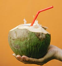 Kokosnöt med sugrör och kokosvatten